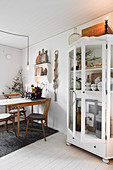 Old glass-fronted cabinet in festively decorated dining room