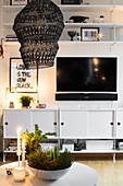 weiße Sideboards, Fernseher und Wandregale im Wohnzimmer