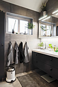 Blick auf Waschtisch im Badezimmer mit grauen Wandfliesen