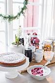 Cake on cake stand and bowl of quark and fruit next to window