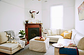 Leather furniture, ottoman with cover and fireplace with wood paneling in a bright living room