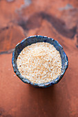 Roasted grated coconut in a blue ceramic bowl