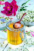 Honey in a glass jar with a wooden spoon