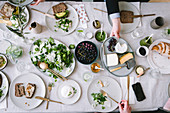 Gedeckter Tisch zum Lunch mit Salat, Brot, Trauben und Käse