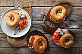 Bagels with salmon fish, cream cheese, cucumber and fresh radish slices on rustic gray wooden background