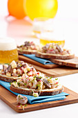 Slices of baguette topped with butter, soused herring, radishes and cress