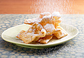 Faworki (Polish carnival pastries) being dusted with icing sugar