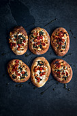 Individual flat breads topped with feta cheese, spinach and tomatoes and drizzle with olive oil