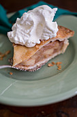 A piece of apple pie with cream