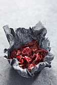 Dried schizandra berries in paper on a grey surface