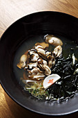 Oysters with black udon noodles in broth (Asia)