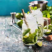 Mojito cocktail with lime and mint in glass jars on the table