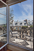 Zwei Stühle auf sonnigem Balkon in Paris