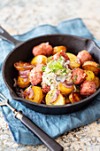 Fried potatoes with sausage in a cast iron pan