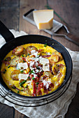 Potato omelette with bacon and parmesan in a pan