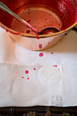 Lingon berry jam being made, an empty pot and spots of jam on a tea towel