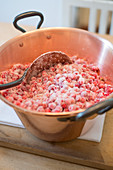 Lingon berry jam being made, raw lingon berries in a pot with sugar