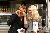 Pärchen vor einem Food Truck, Mann mit Donuts vor den Augen