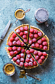 Freshly baked custard tart decorated with fresh raspberries on a table