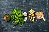 Ingredients for making pesto sauce on a black old background, top view