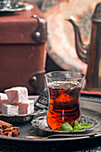 Turkish tea in traditional glass cup with turkish delight