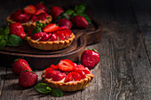 Fresh homemade strawberries tarts on wooden background