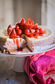Strawberry cheesecake on a cake stand, sliced