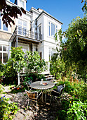 Terrassenplatz mit rundem Tisch und Stühlen vor Wohnhaus