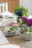 Spring flowers in vintage cake tins decorating table
