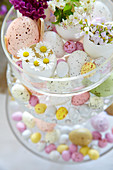 Easter eggs and flowers on glass cake stand