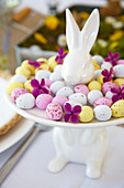 Colourful sugar eggs on white presentation plate with Easter bunny motif