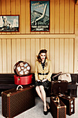 A young woman with suitcases sitting in a station waiting room