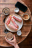 French eclairs and two cups of coffee on the table