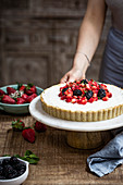 Erdbeer-Mascarponetarte garniert mit Beeren auf Kuchenständer