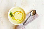 Cremesuppe mit weissen Bohnen, Kokos und Basilikum serviert mit Zitronengrasöl