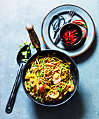 Singapore noodles with fish, shrimp, chili peppers, peas and peppers (Asia)