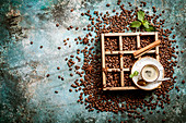 Coffee beans in old wooden box, cup of fresh making coffee