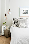Two pendant lamps above bedside table against grey wall