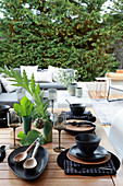 Table set with black crockery on terrace
