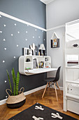 Wall-mounted shelving unit with integrated fold-down desk in child's bedroom
