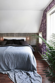 Bedroom with wood-panelled knee wall below sloping ceiling