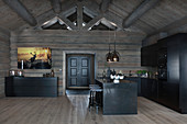 Modern log cabin with dark wooden furnishings and black fitted kitchen