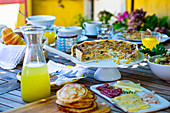 Brunch with quiche, pancakes, sausage, cheese and orange juice