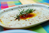 The remains of a marinade and rosemary on a serving platter