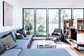 L-shaped couch with storage space and shelf as a room divider in a bright living area