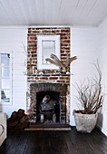 Rustikaler Backstein-Kamin im Wohnzimmer mit weiß gestrichenen Holzwänden