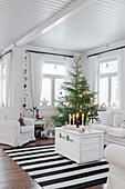 Weiße Holztruhe als Couchtisch und Weihnachtsbaum im Wohnzimmer