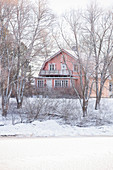 Red wooden house in snowy landscape