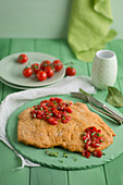 Giant schnitzel with caramelised cherry tomatoes