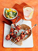 Grilled salmon tikka skewers with a yoghurt dip and cucumber salad